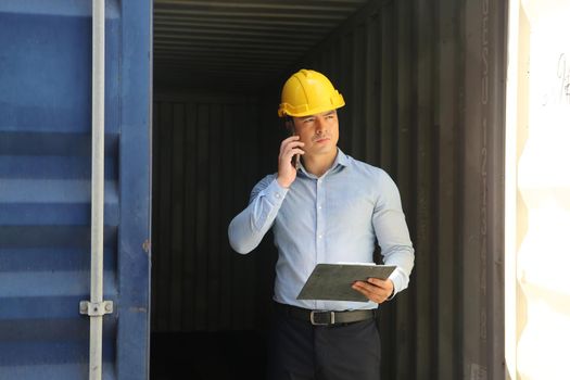 Foreman control loading Containers box from Cargo freight ship for import export.