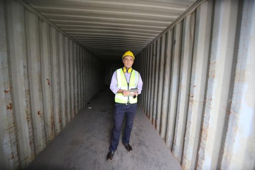 Foreman control loading Containers box from Cargo freight ship for import export.
