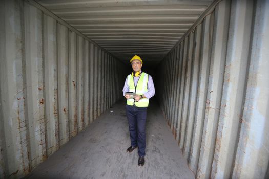 Foreman control loading Containers box from Cargo freight ship for import export.