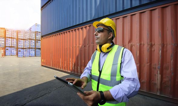 Foreman control loading Containers box from Cargo freight ship for import export.