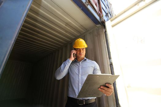 Foreman control loading Containers box from Cargo freight ship for import export.
