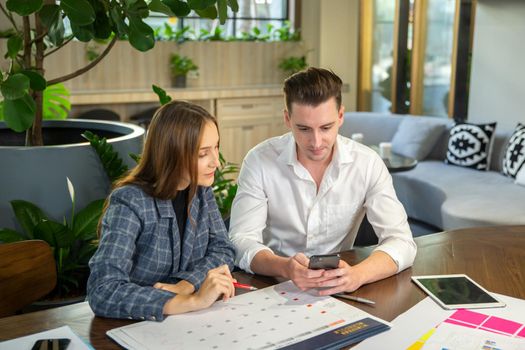 Close-up image of two attractive young people having a business meeting in a modern cafe.