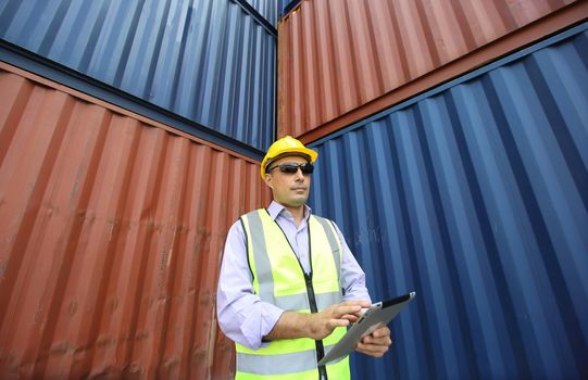  supervisor checking and control loading Containers box from Cargo at harbor. Foreman control Industrial Container Cargo freight ship at industry. Transportation and logistic concept.