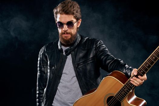 Male musician in leather jacket performed by musical group guitar. High quality photo
