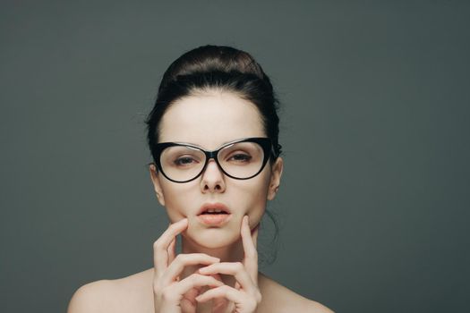 portrait of beautiful brunette with glasses naked shoulders gesturing with hands. High quality photo