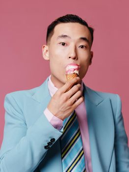 Man in blue classic suit with ice cream portrait pink background model close-up . High quality photo
