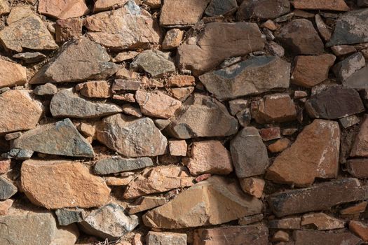 Stone wall of an old house in a village in southern Andalusia in Spain