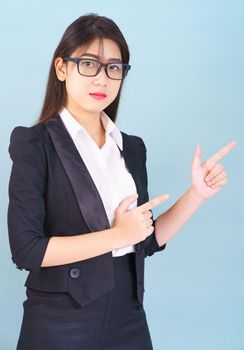 Young Asain women in suit standing using her digital tablet against blue background