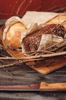 a loaf of fresh bread flour product in a bird's nest on a wooden table on a red background. High quality photo