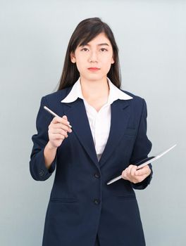 Asian woman in suit using computer digital tablet isolated on gray background