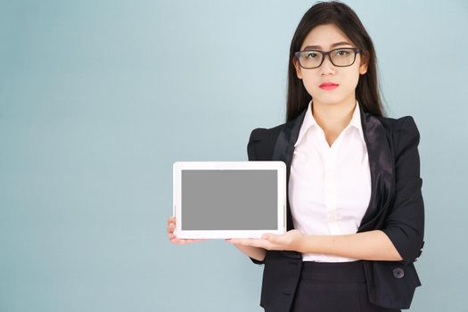 Young asian women in suit holding her digital tablet standing against green background