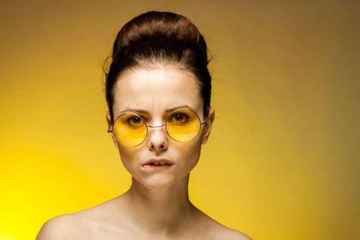 brunette with bare shoulders yellow glasses attractive look. High quality photo