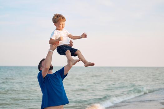 Father throwing son spending time together sea vacation Young dad child little boy walking beach Fathers day. Family with one child. Happy childhood with daddy.