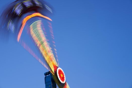 Amusement park blurred effect. Abstract illuminated background Spinning defocused carnival carousel long exposure shooting
