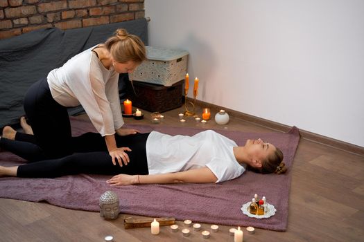 Relax and enjoy in spa salon getting thai massage by professional masseur Woman lying floor blanket Body care Hands treatment Acupressure trigger points Prevention muscles pain stretching flexibility