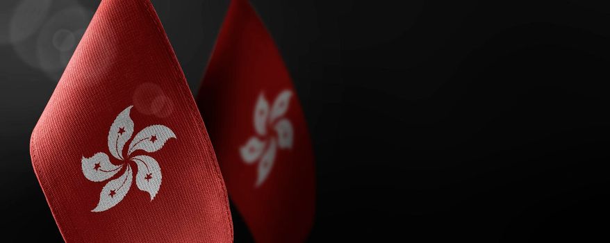 Small national flags of the Hong Kong on a dark background.