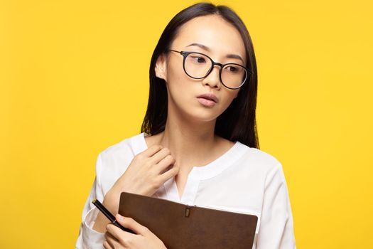 woman of asian appearance white shirt notepad in hands work manager. High quality photo