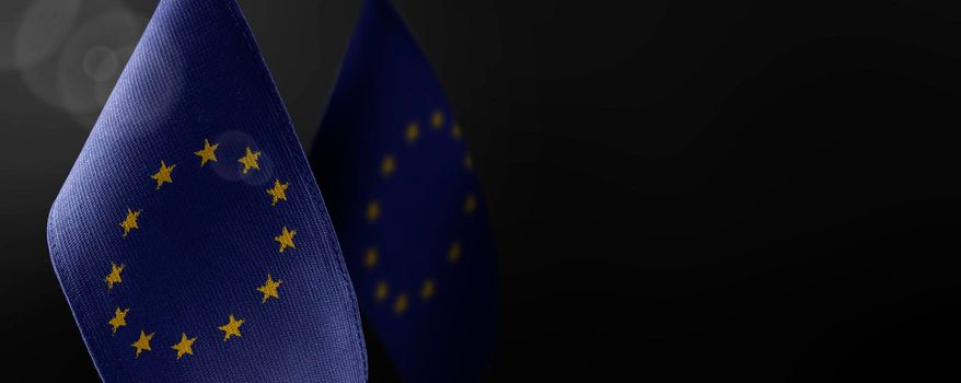 Small national flags of the European Union on a dark background.