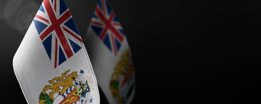 Small national flags of the British Antarctic Territory on a dark background.