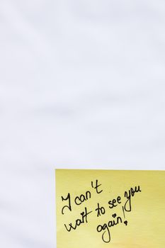 I can not wait to see you again handwriting text close up isolated on yellow paper with copy space.