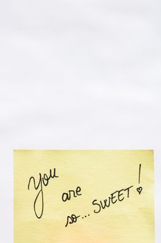 You are so sweet handwriting text close up isolated on yellow paper with copy space.