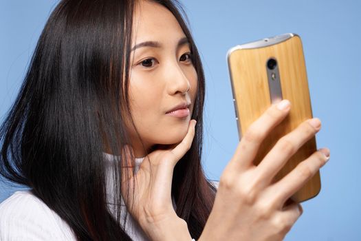 woman of asian appearance with a phone in hands communication internet technology. High quality photo