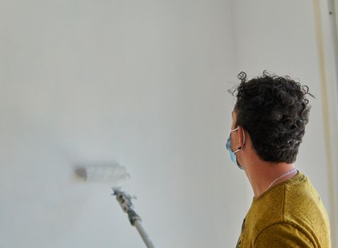 Painter painting a white room with a roller