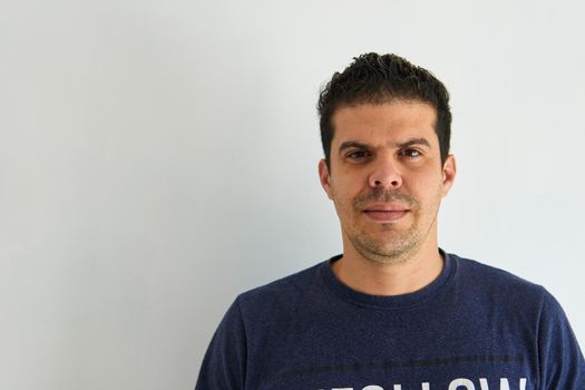 Portrait of a worker in a blue shirt while painting a room