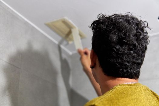 Painter preparing to paint a room with masking tape