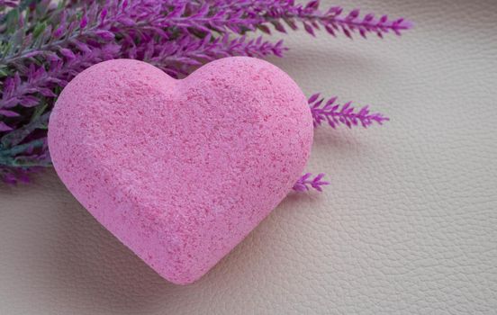 Purple heart bath salt and a branch of artificial lavender on a white background. Space for text.