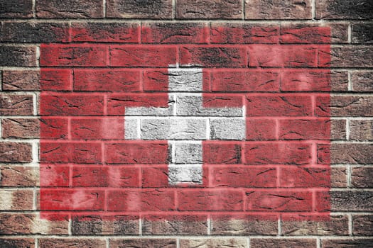 A Switzerland flag on a brick wall background
