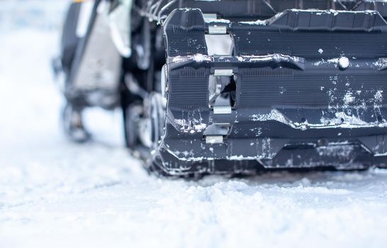 The back of the snowmobile in winter. Riding in the snow on a snowmobile. Rear suspension of a snowmobile