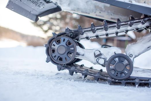 The back of the snowmobile in winter. Riding in the snow on a snowmobile. Rear suspension of a snowmobile