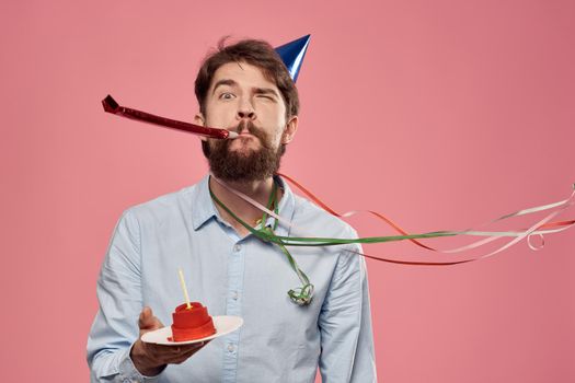 Bearded man with cake on pink background birthday party corporate emotions model loneliness. High quality photo