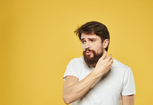 Emotional guy gesturing with his hands on a yellow background model side view. High quality photo