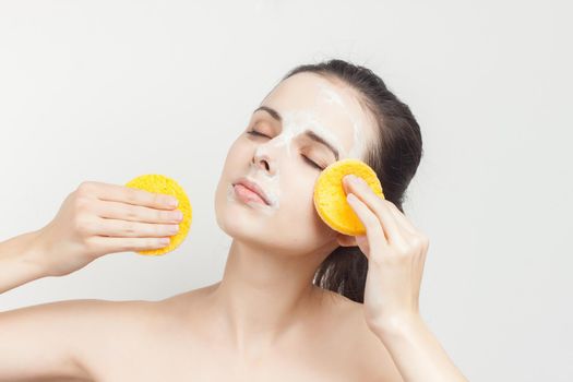 woman with bare shoulders wipes the mask with sponges. High quality photo