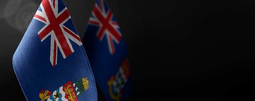 Small national flags of the Cayman Islands on a dark background.