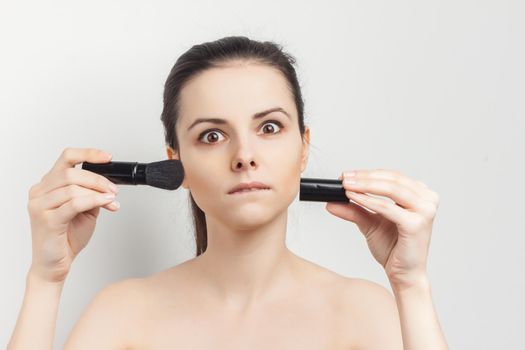 woman with bare shoulders brush in hands cosmetics skin care. High quality photo