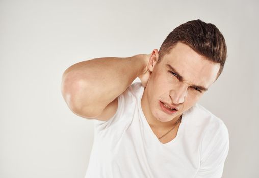 Nice guy in a white T-shirt on a light background cropped view portrait close-up. High quality photo