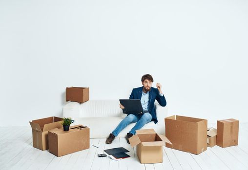 Man sitting on couch boxes with things new place of work office professional. High quality photo