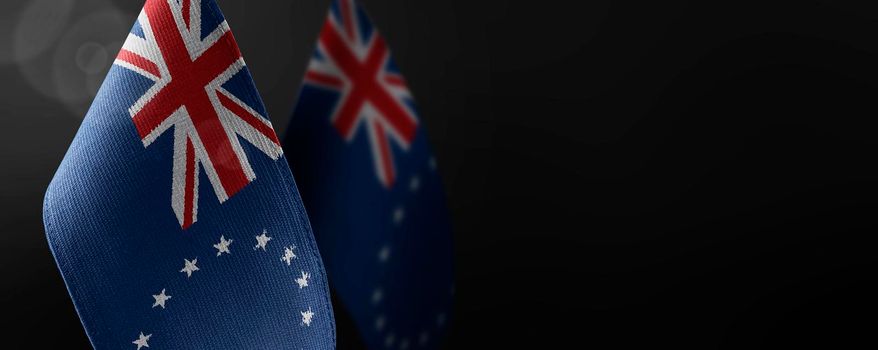 Small national flags of the Cook Islands on a dark background.