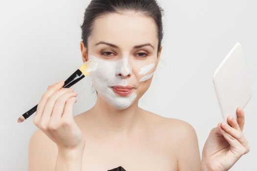 woman with face cream mask skin care naked shoulders spa treatments. High quality photo