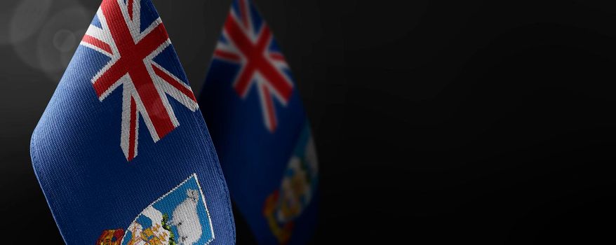 Small national flags of the Falkland Islands on a dark background.