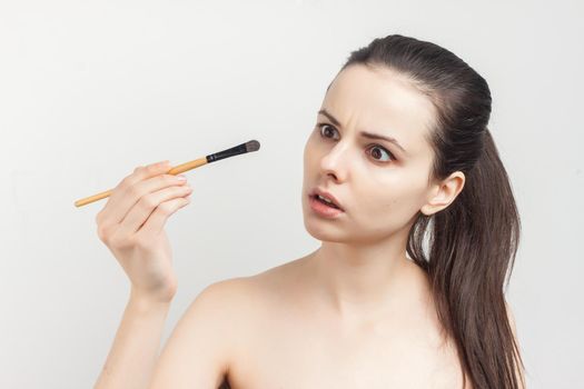 woman with bare shoulders brush in hands cosmetics skin care. High quality photo