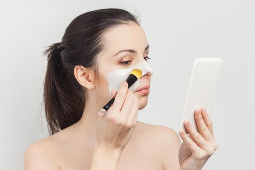 woman with bare shoulders brush in hands cosmetics skin care. High quality photo