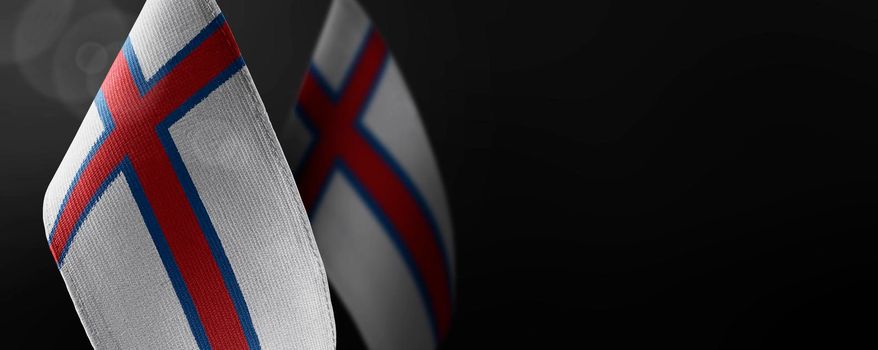 Small national flags of the Faroe Islands on a dark background.