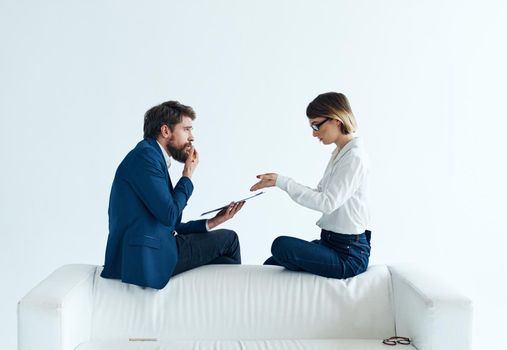 Woman and man are sitting on the couch in suits documents psychology staff. High quality photo