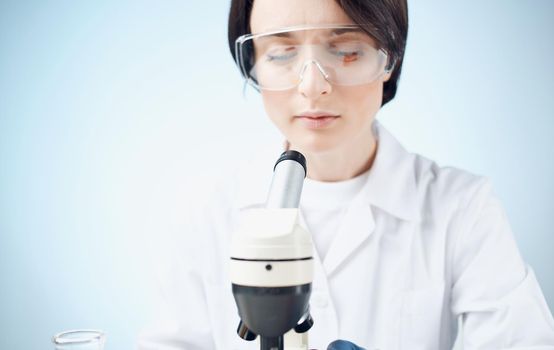 doctors in medical gloves look through a microscope on the table e laboratory chemical element vaccine. High quality photo