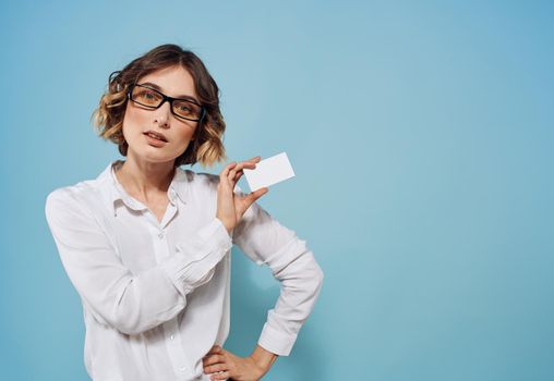 woman with white letterhead in hands shirt glasses hairstyle blue background. High quality photo