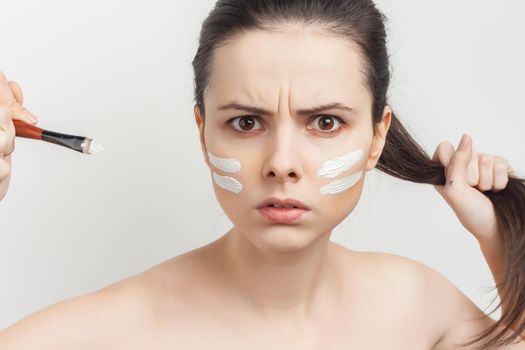 emotional brunette with face mask naked shoulders skincare. High quality photo